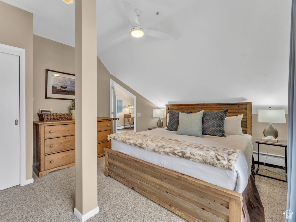 Carpeted bedroom with a baseboard heating unit, vaulted ceiling, baseboards, and ceiling fan