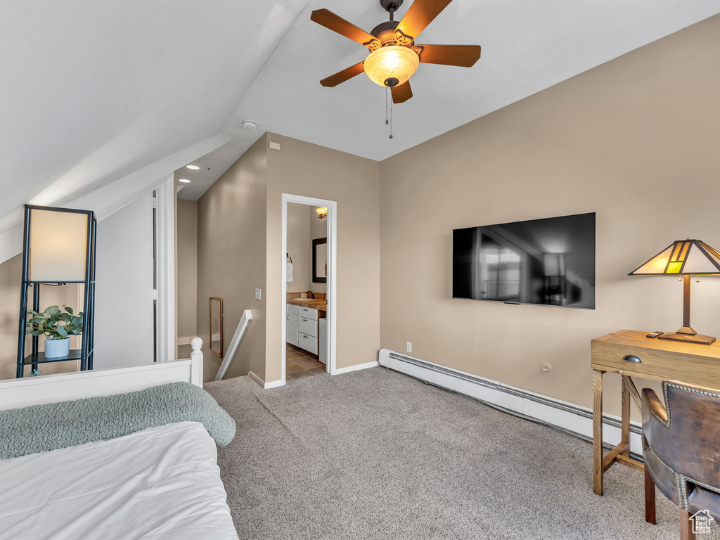 Carpeted bedroom with a baseboard heating unit, lofted ceiling, baseboards, ceiling fan, and ensuite bath