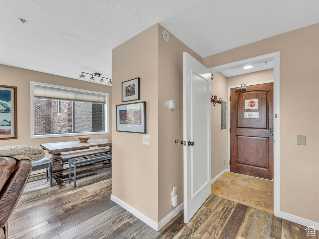 Foyer with baseboards and wood finished floors