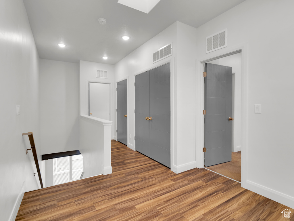 Spare room featuring wood finished floors, baseboards, a skylight, recessed lighting, and a smoke detector