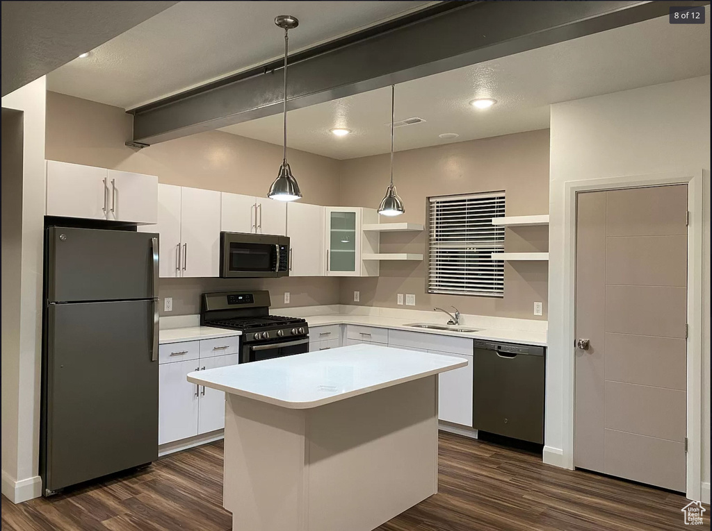 Kitchen featuring appliances with stainless steel finishes, open shelves, a sink, dark wood-style floors, and white cabinetry