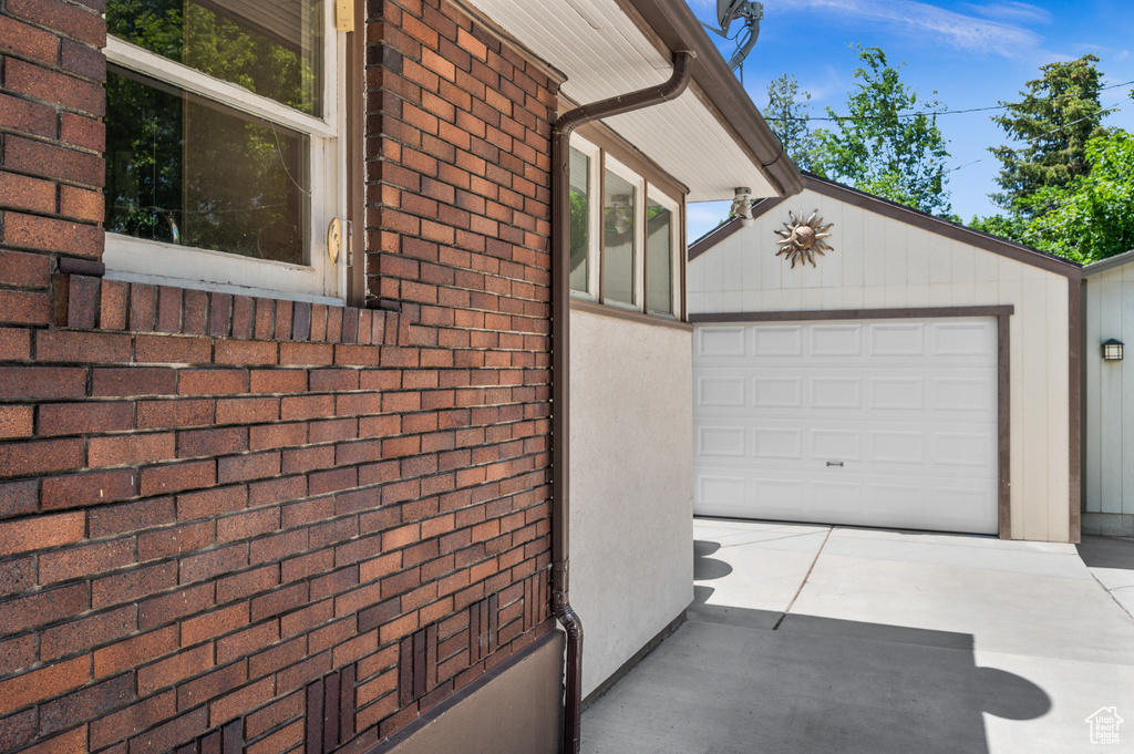 View of side of property featuring driveway and brick siding