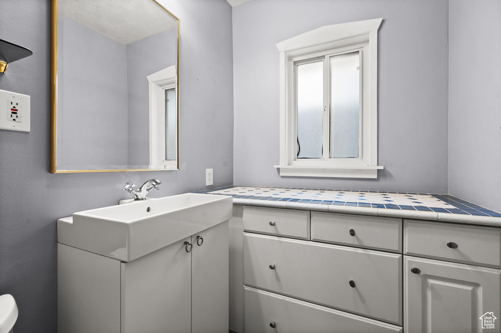 Half bathroom with vanity and toilet