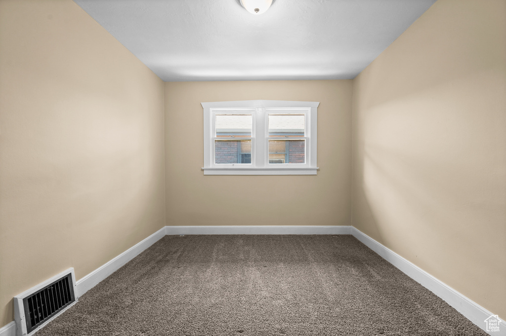 Carpeted empty room featuring baseboards