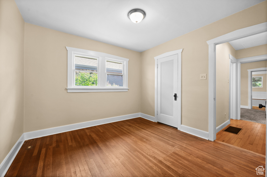 Unfurnished bedroom with hardwood / wood-style flooring and baseboards