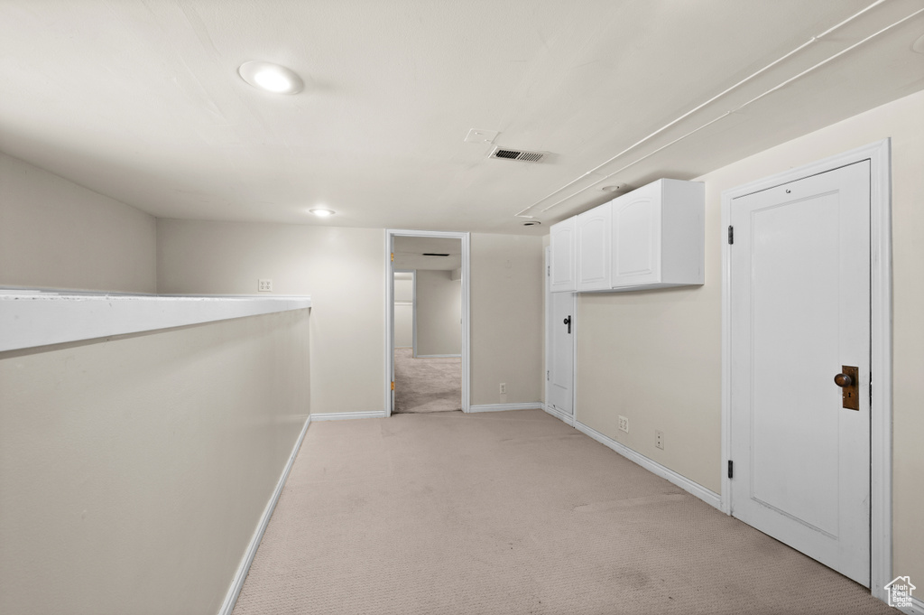 Corridor with light colored carpet, baseboards, and recessed lighting