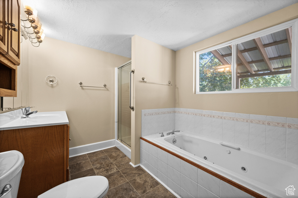 Full bathroom with toilet, a jetted tub, a stall shower, baseboards, and double vanity
