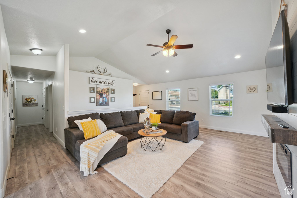 Living area featuring lofted ceiling, a ceiling fan, light wood-style floors, baseboards, and recessed lighting