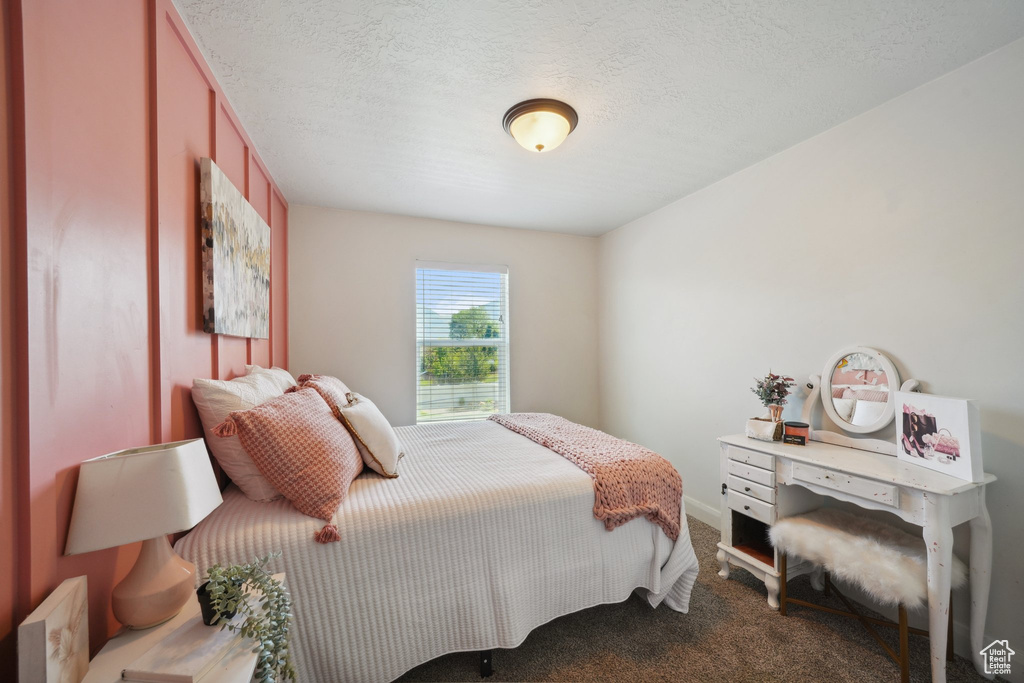 Carpeted bedroom featuring a textured ceiling