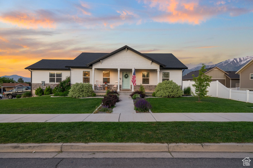 View of front of house with a porch and stone siding