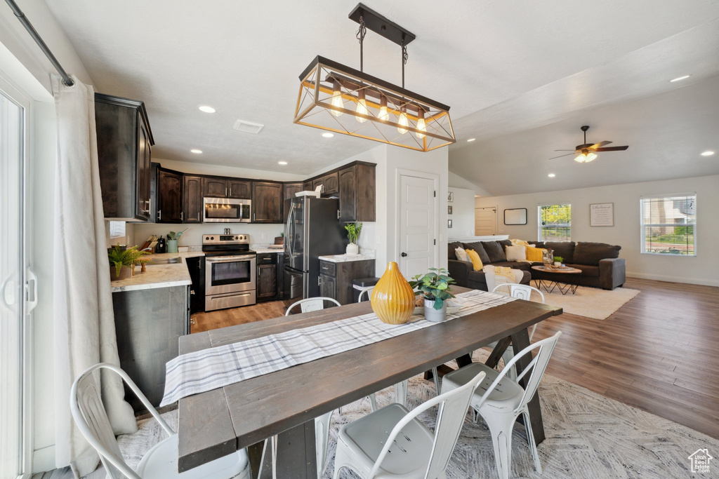 Dining space featuring light wood finished floors, recessed lighting, ceiling fan, and vaulted ceiling