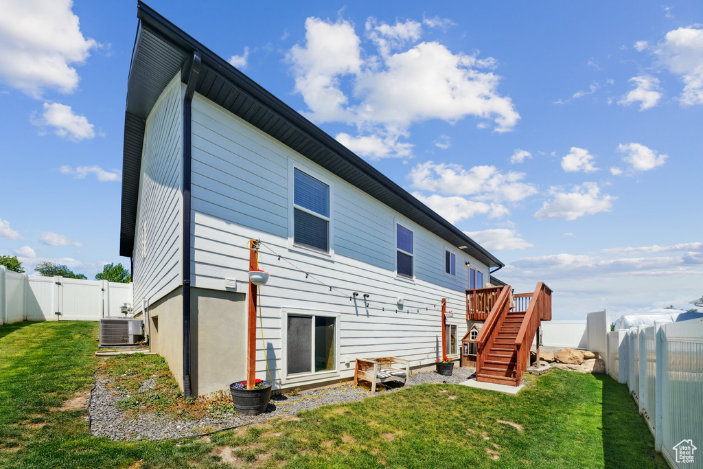 Back of house featuring cooling unit, a gate, stairs, and a wooden deck