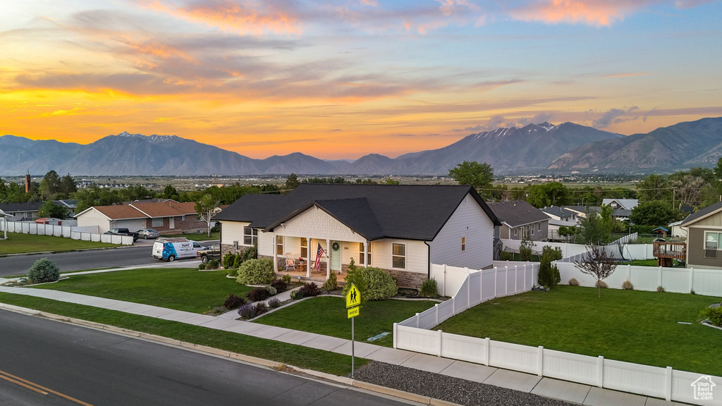 View of front of house featuring covered porch, stone siding, a mountain view, and a residential view