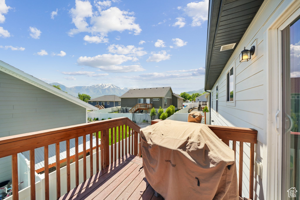 Wooden deck featuring a residential view and a mountain view