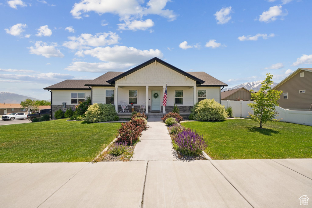 View of front of property featuring covered porch and stone siding