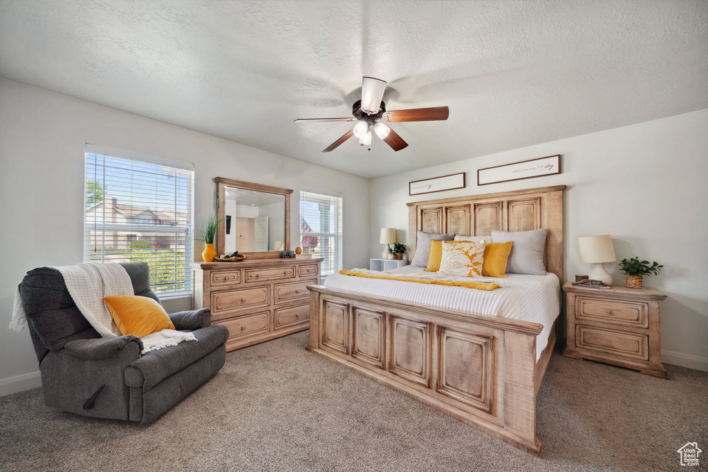 Bedroom with light colored carpet, a ceiling fan, and baseboards