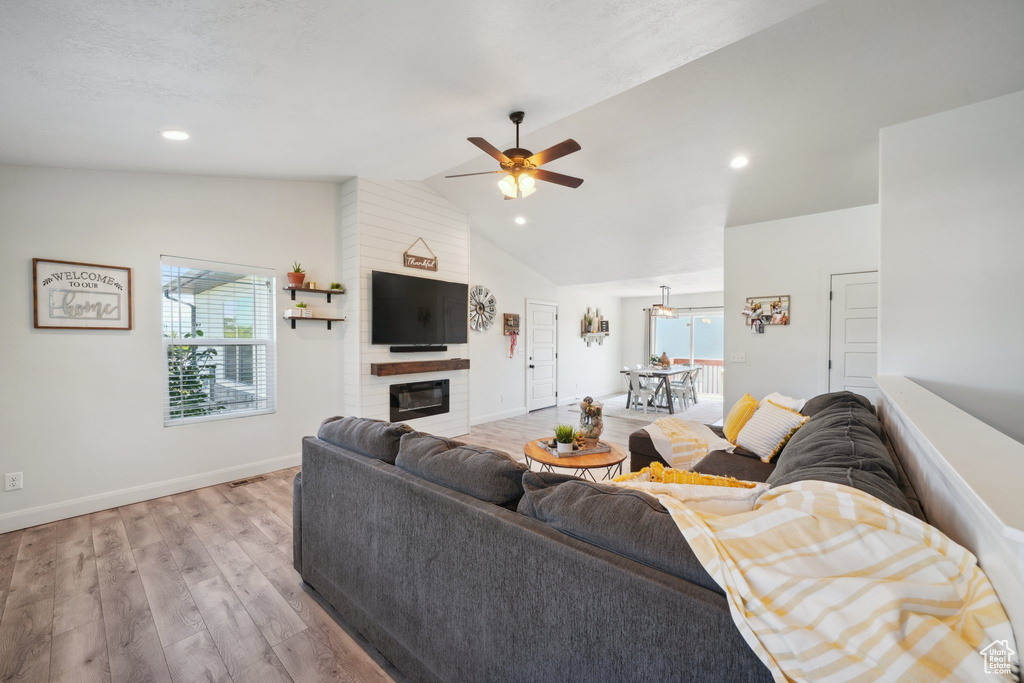 Living area featuring ceiling fan, light wood-type flooring, a large fireplace, baseboards, and recessed lighting