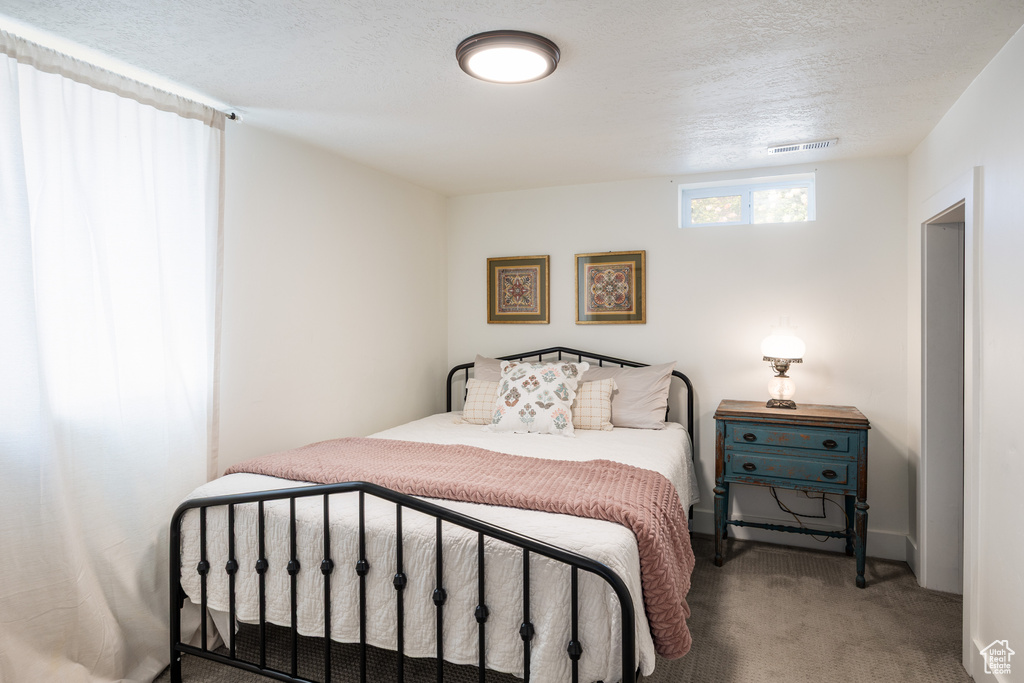 Carpeted bedroom featuring a textured ceiling
