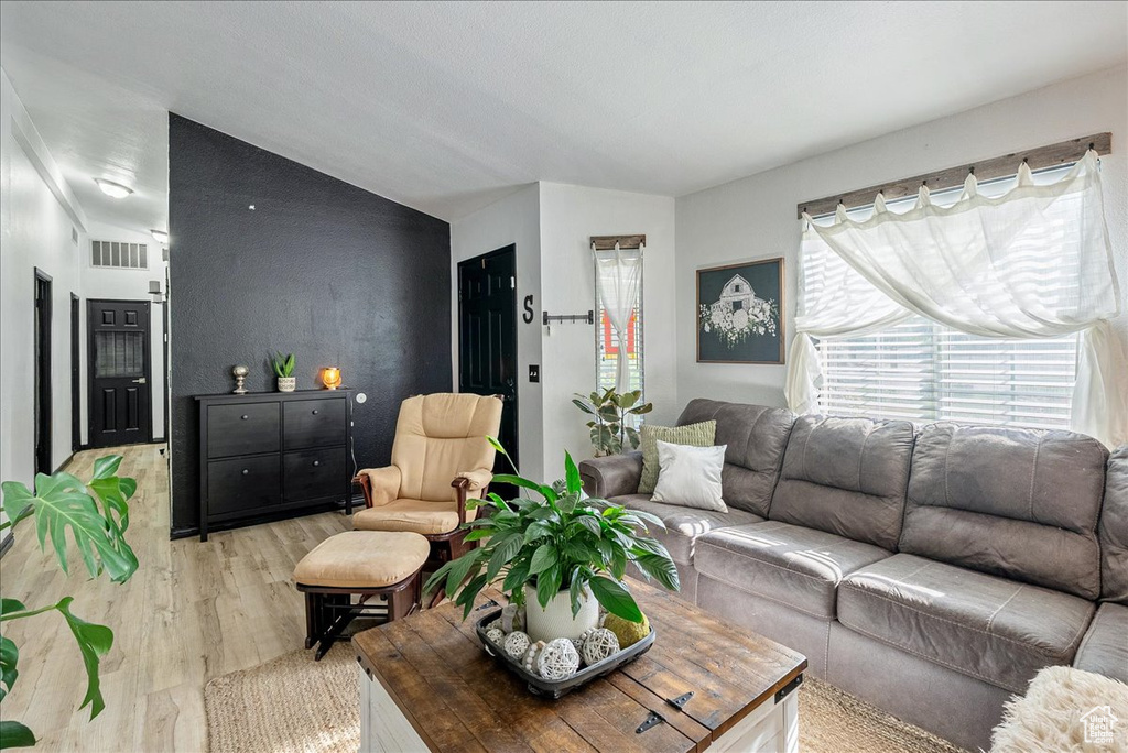Living room featuring light wood-style floors and lofted ceiling