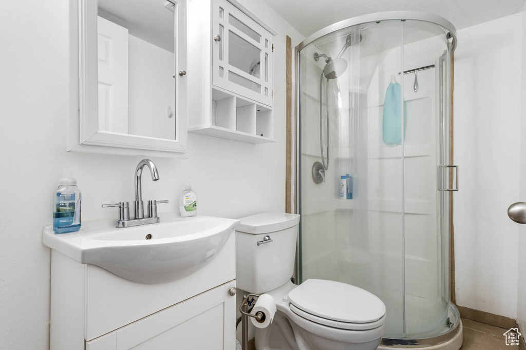 Full bath with a stall shower, vanity, and toilet