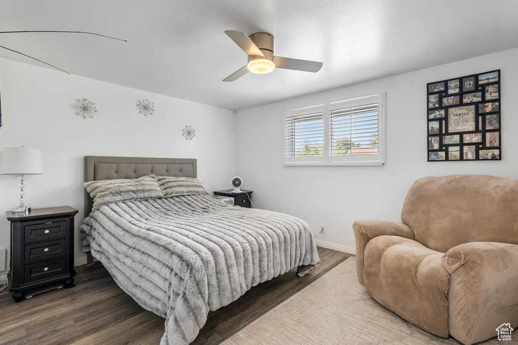 Bedroom with wood finished floors, baseboards, and a ceiling fan