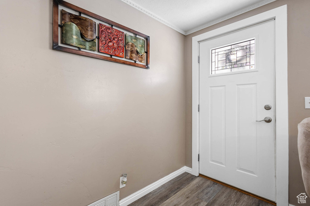 Entrance foyer featuring baseboards, ornamental molding, and wood finished floors