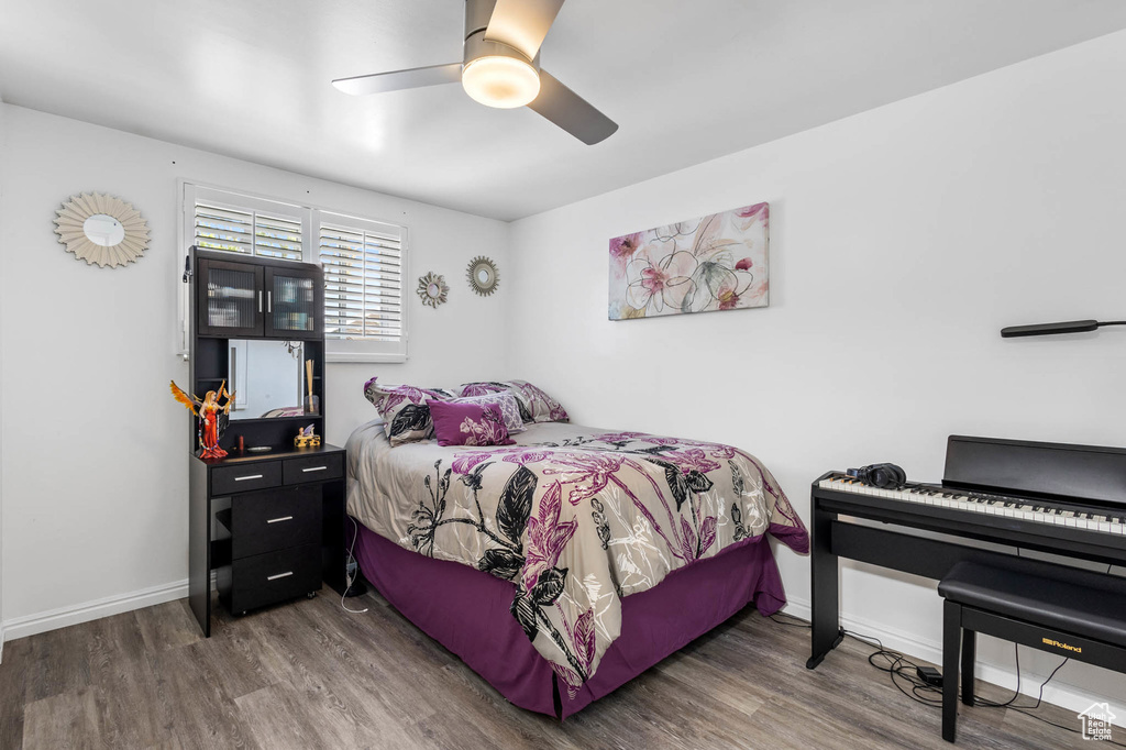 Bedroom featuring wood finished floors, baseboards, and a ceiling fan