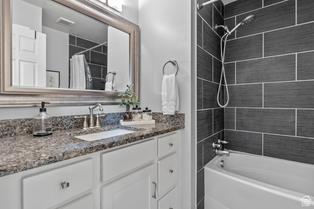 Bathroom with vanity and shower / tub combo
