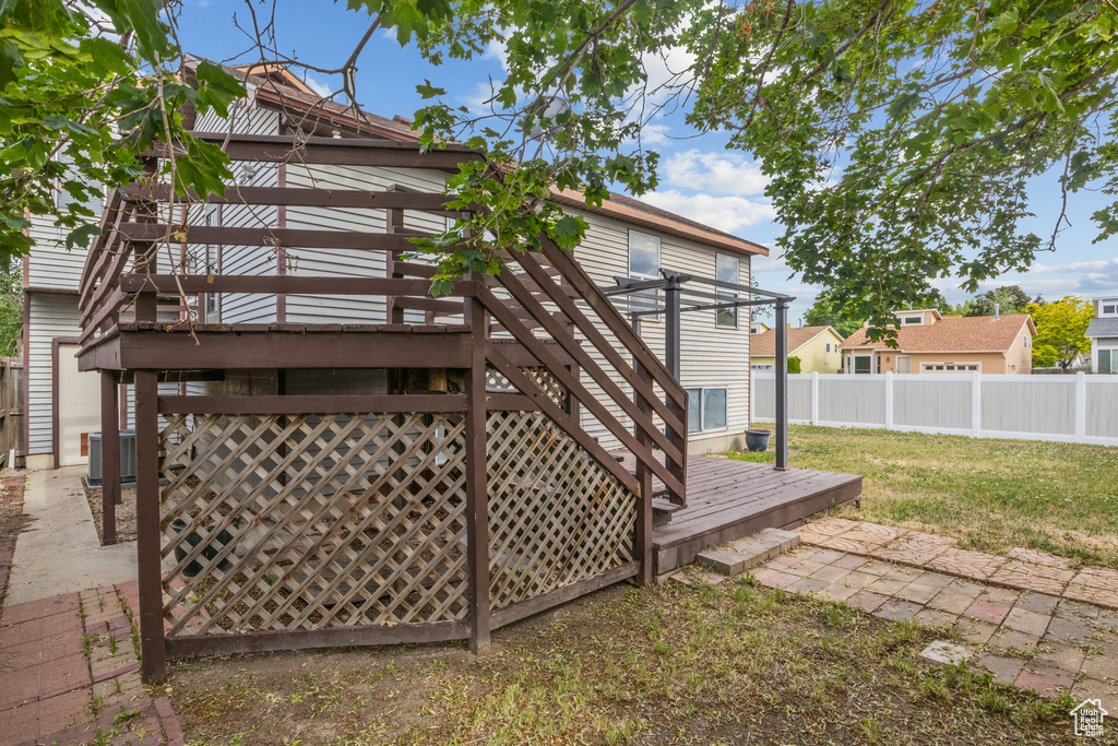 Back of house with a wooden deck, a patio, and cooling unit