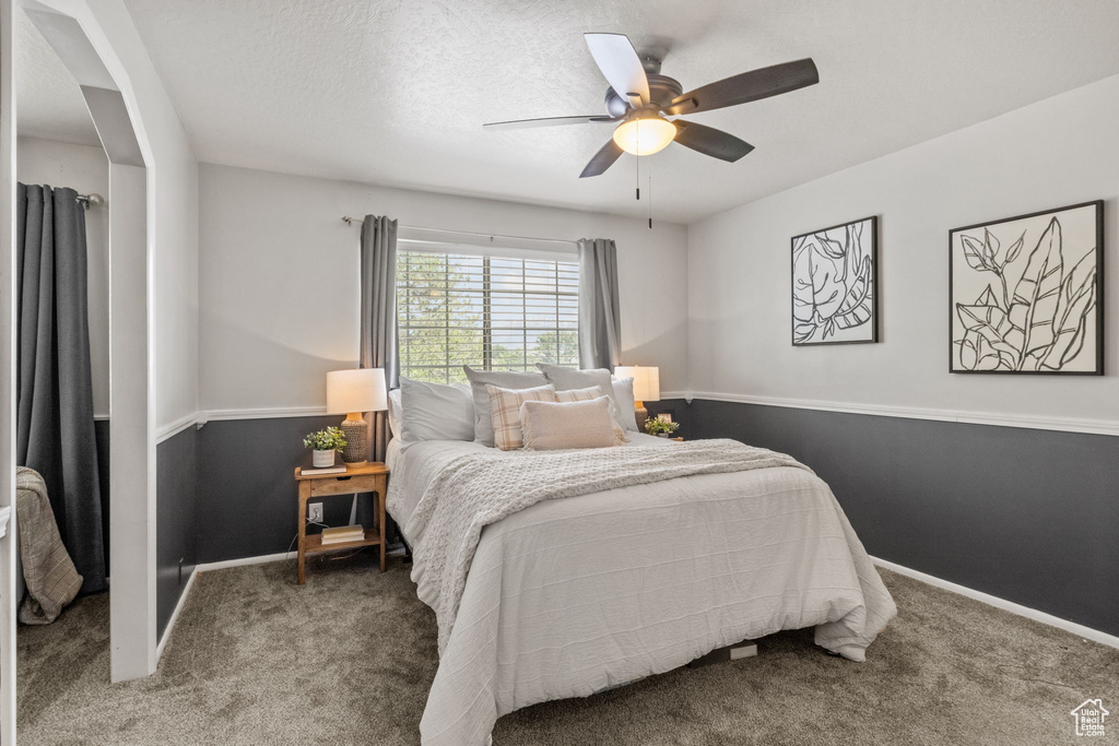 Bedroom with carpet flooring, baseboards, and a ceiling fan