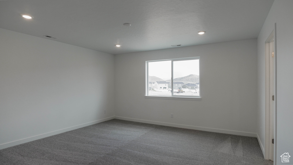 Carpeted spare room with recessed lighting and baseboards