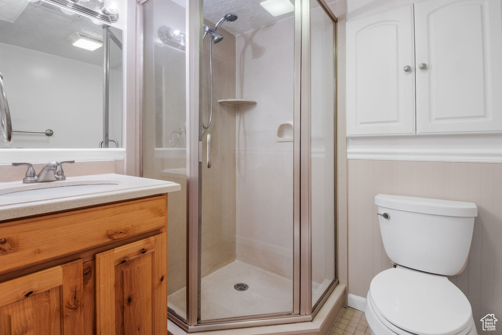 Bathroom with vanity, a stall shower, and toilet