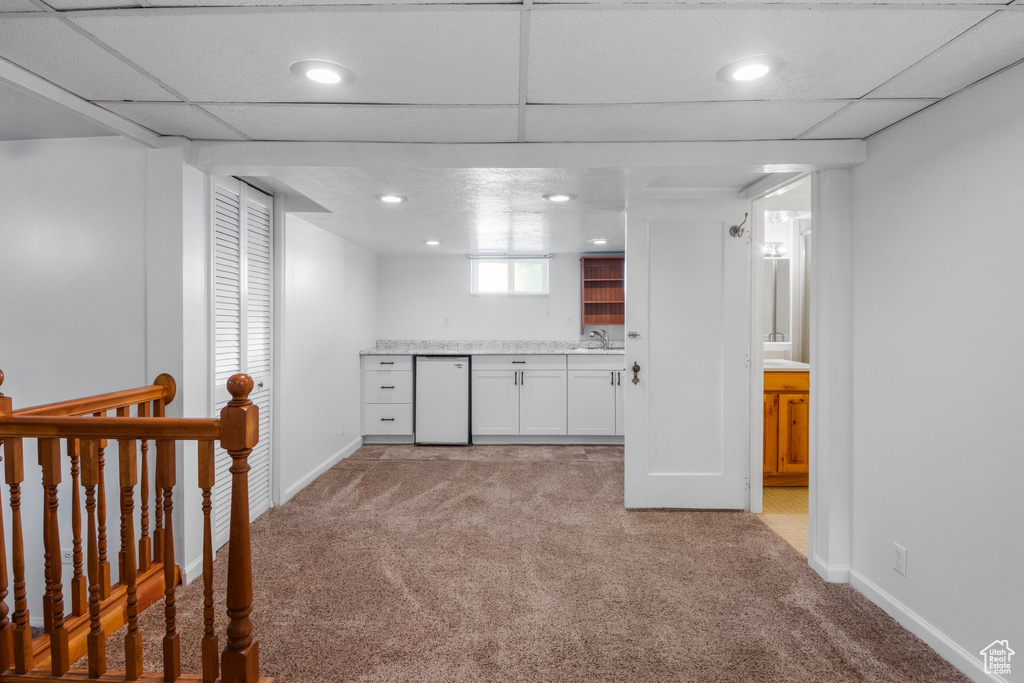 Bar area with light carpet, refrigerator, baseboards, a sink, and recessed lighting
