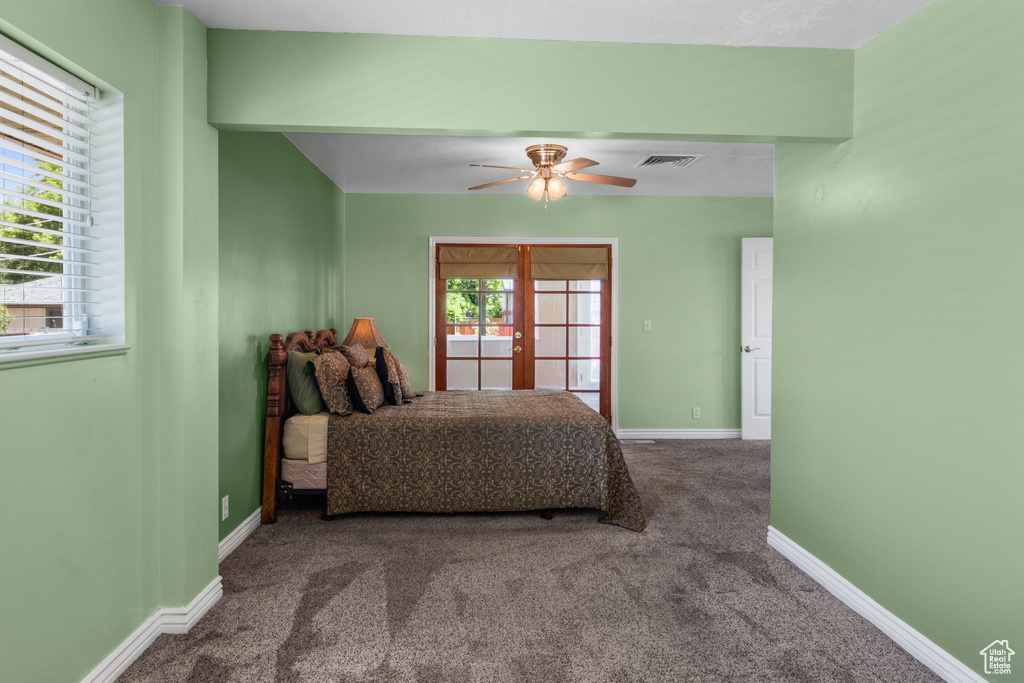 Carpeted bedroom with baseboards, ceiling fan, and french doors