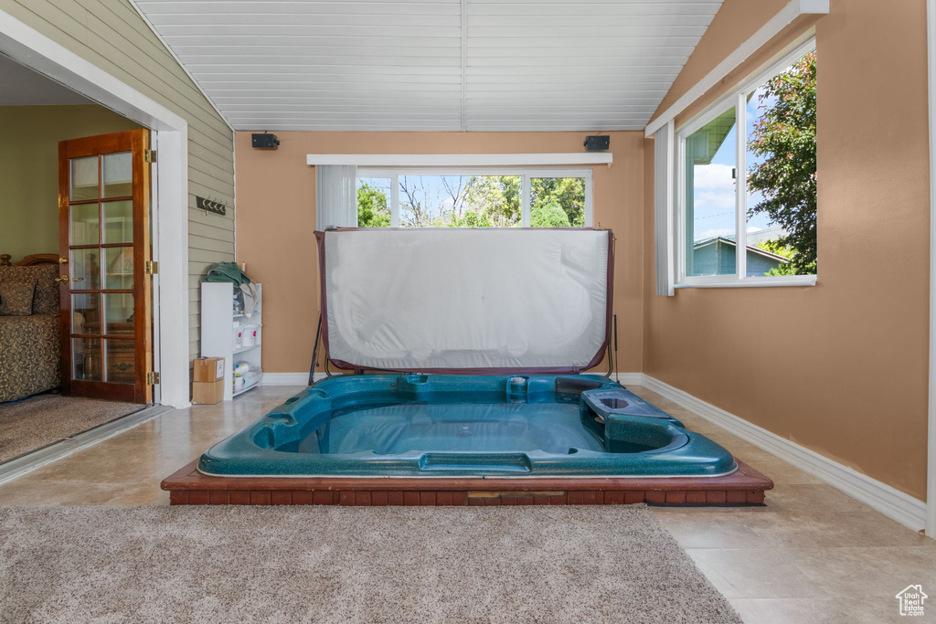 Sunroom / solarium featuring a hot tub and lofted ceiling