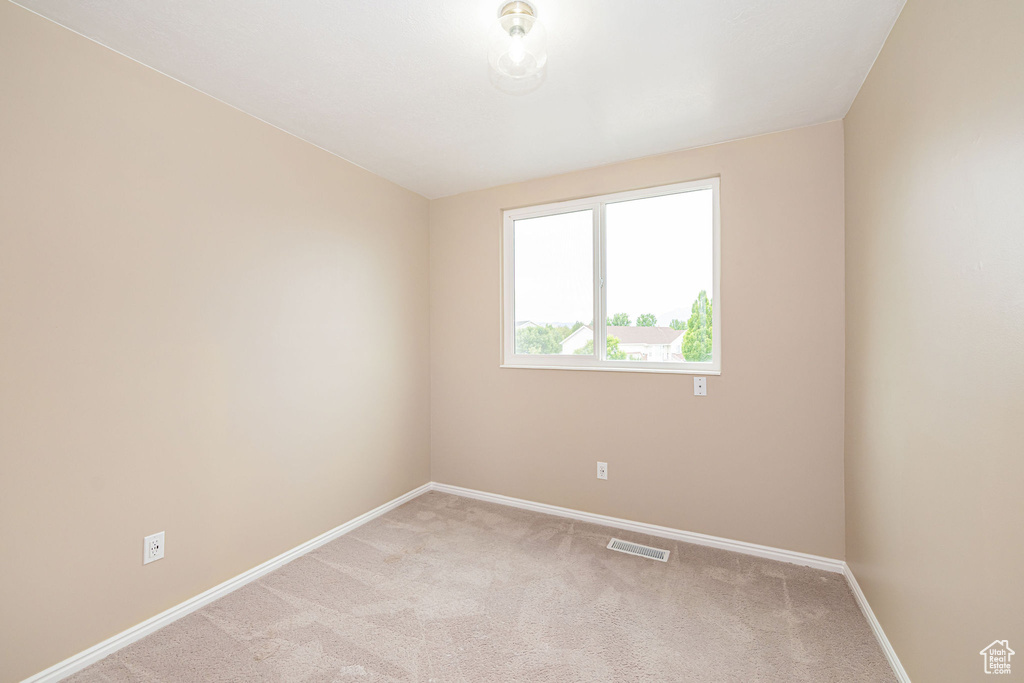 Spare room with light carpet and baseboards