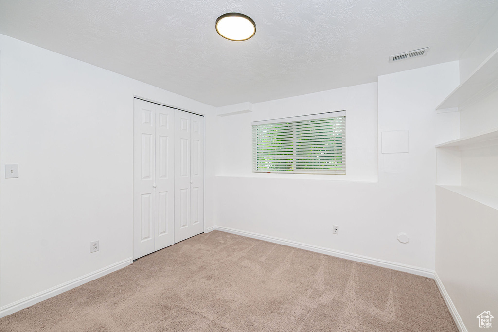 Unfurnished bedroom with carpet floors, baseboards, and a closet