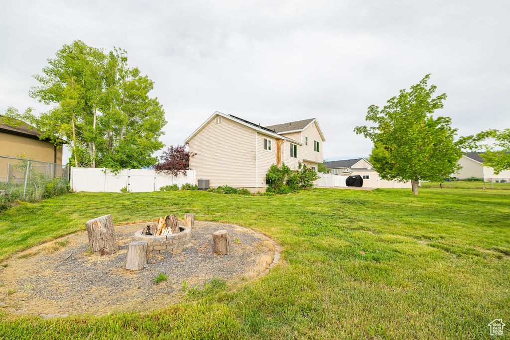 View of yard featuring an outdoor fire pit and central AC