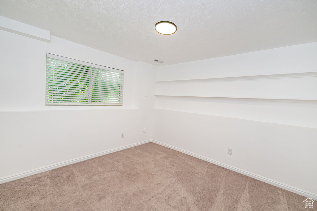 Carpeted empty room with baseboards