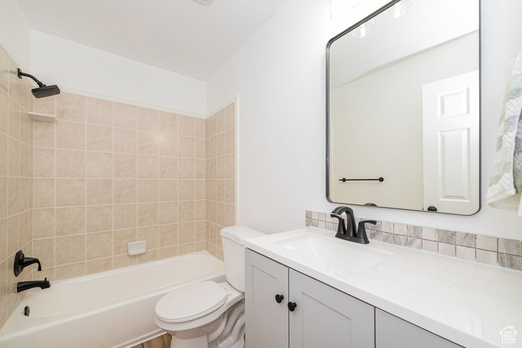 Full bathroom with toilet, vanity, and  shower combination