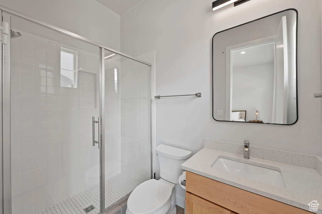 Full bath featuring vanity, toilet, and a stall shower