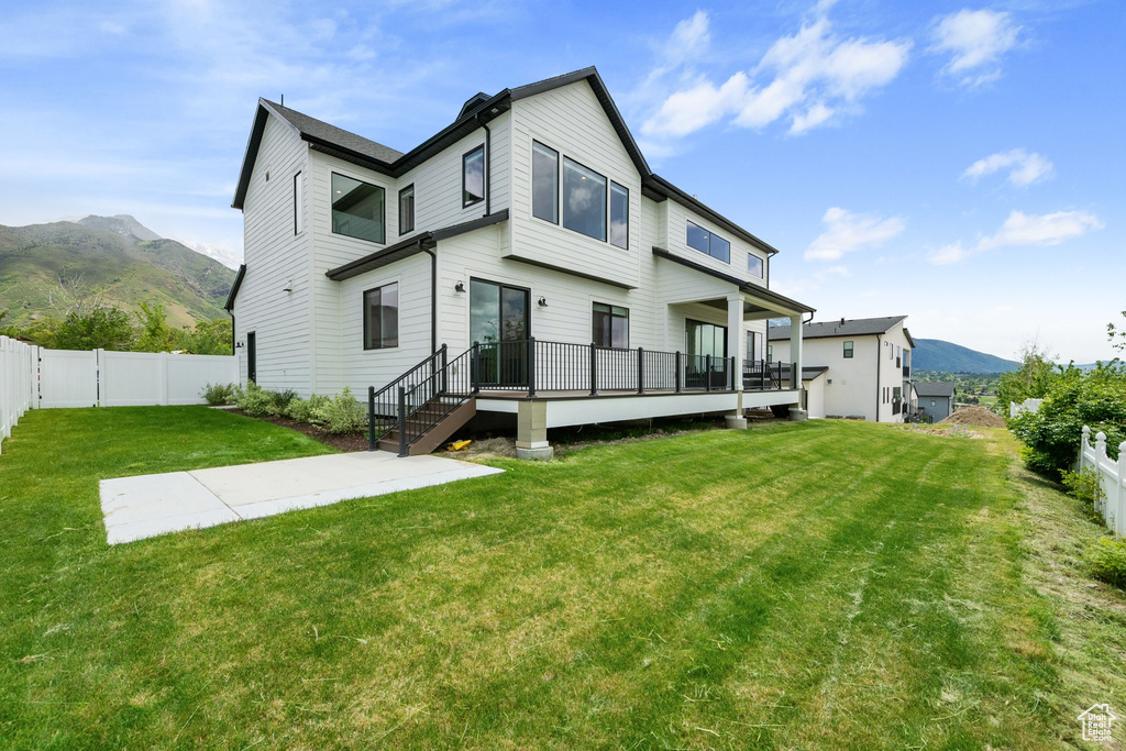 Back of property featuring a deck with mountain view