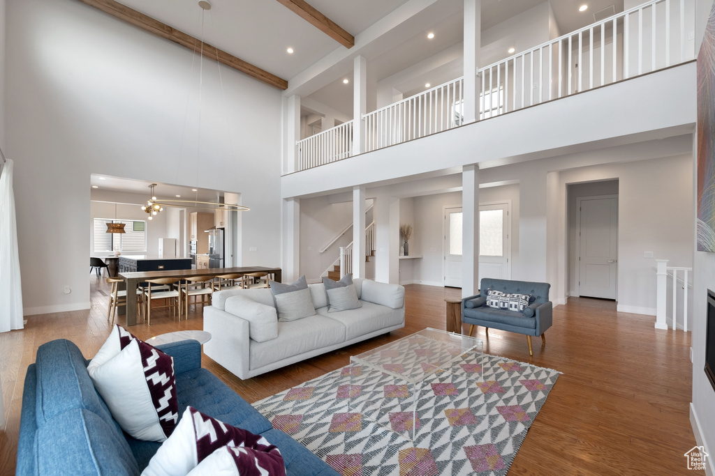 Living area featuring a high ceiling, plenty of natural light, wood finished floors, recessed lighting, and baseboards