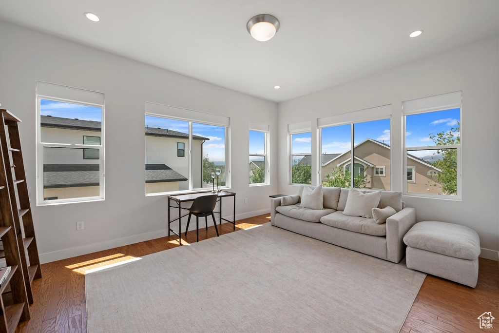 Living area with baseboards, wood finished floors, and recessed lighting