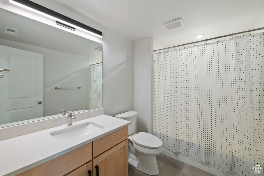 Bathroom featuring vanity, toilet, and a shower with shower curtain