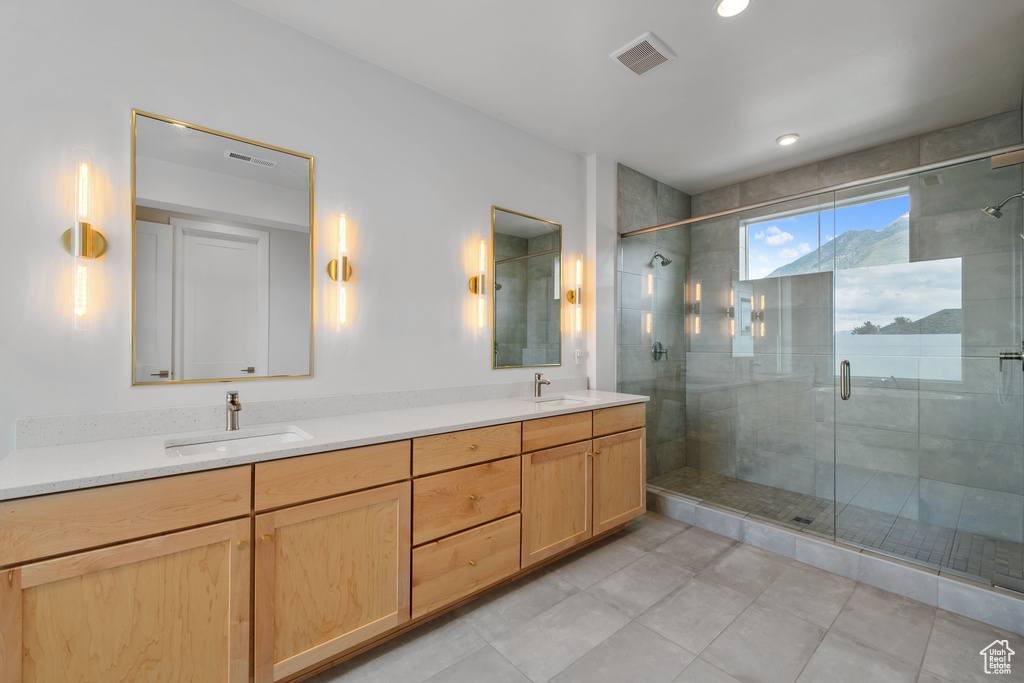 Full bath with a shower stall, double vanity, and recessed lighting