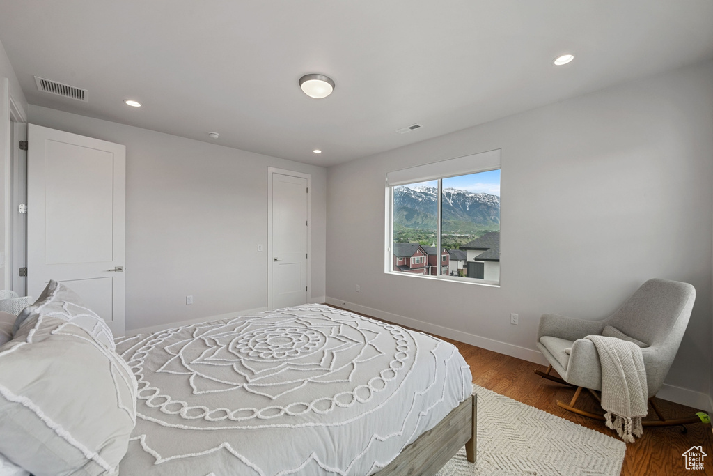 Bedroom with wood finished floors, baseboards, recessed lighting, and a mountain view
