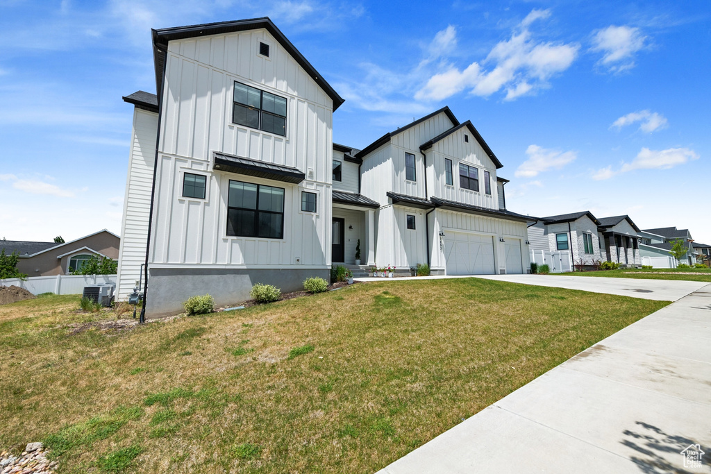 Modern farmhouse with board and batten siding, driveway, an attached garage, and a residential view