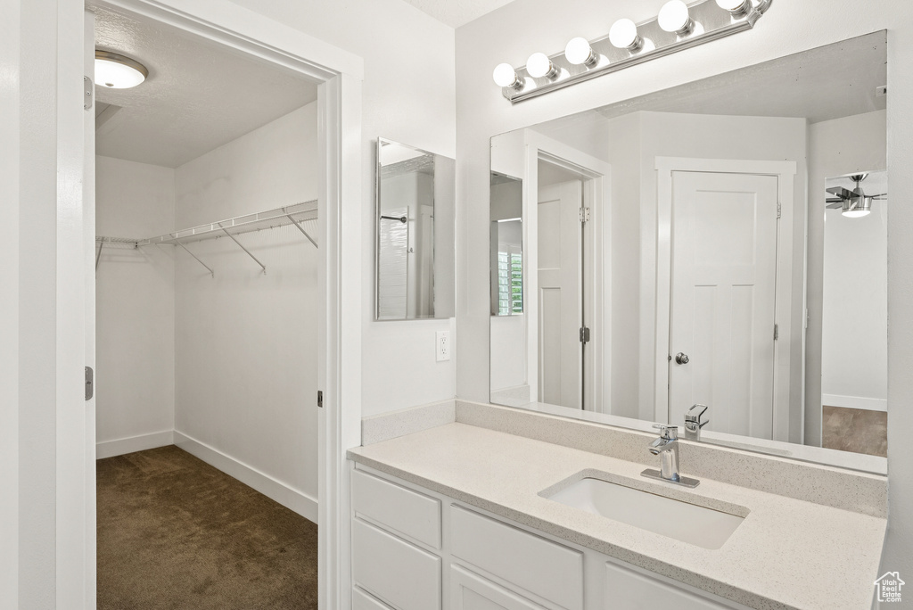 Bathroom featuring vanity and a spacious closet