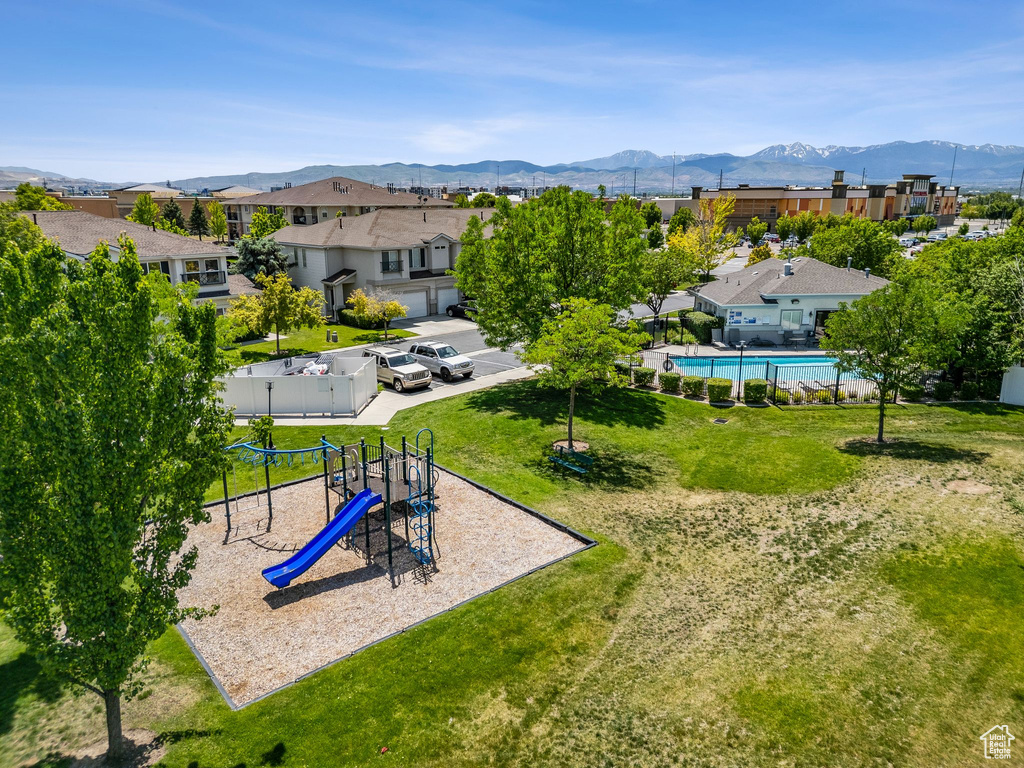 Communal playground featuring a mountain view and a residential view